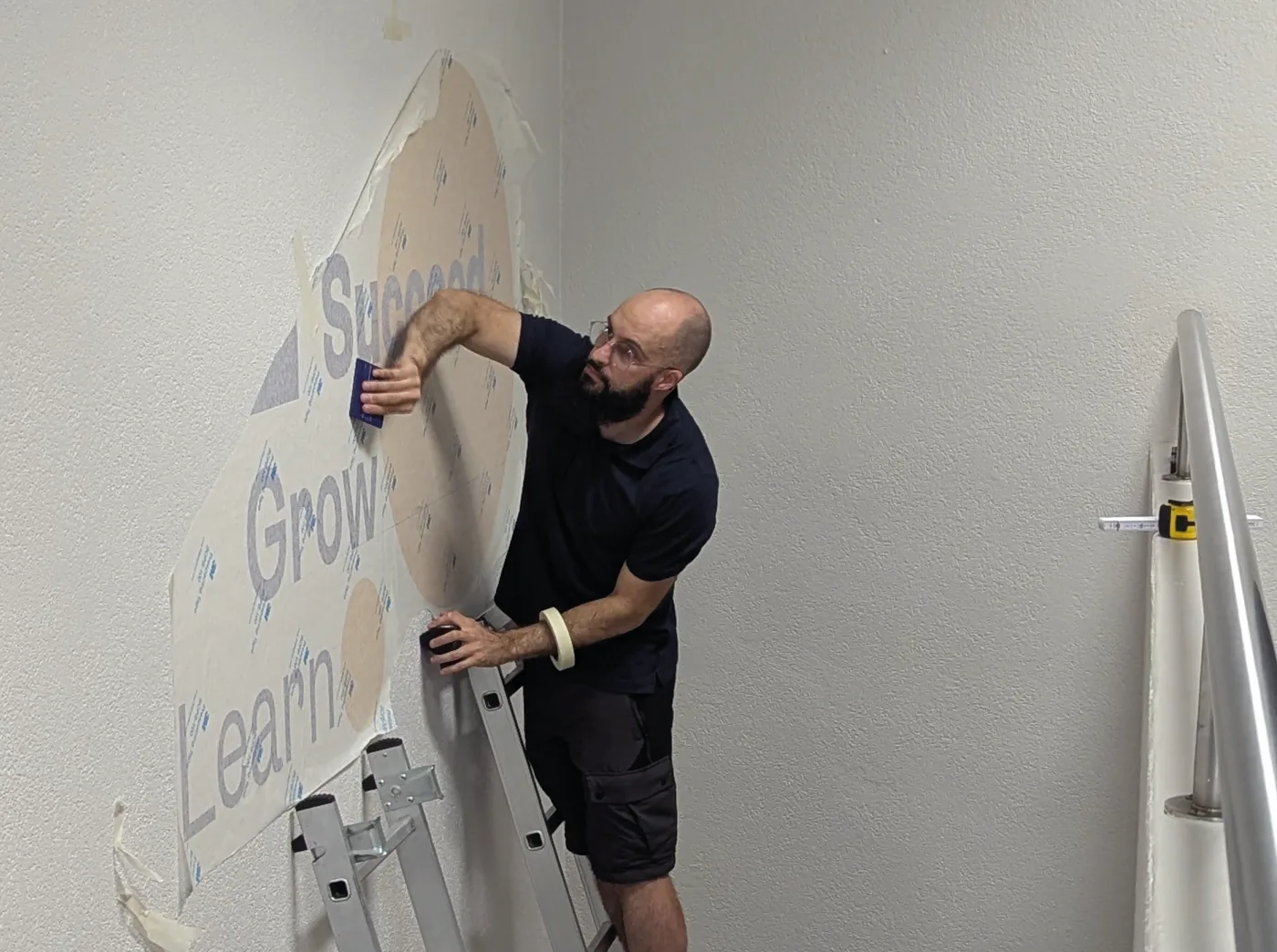 Installation — pose d’un adhésif mural sur site