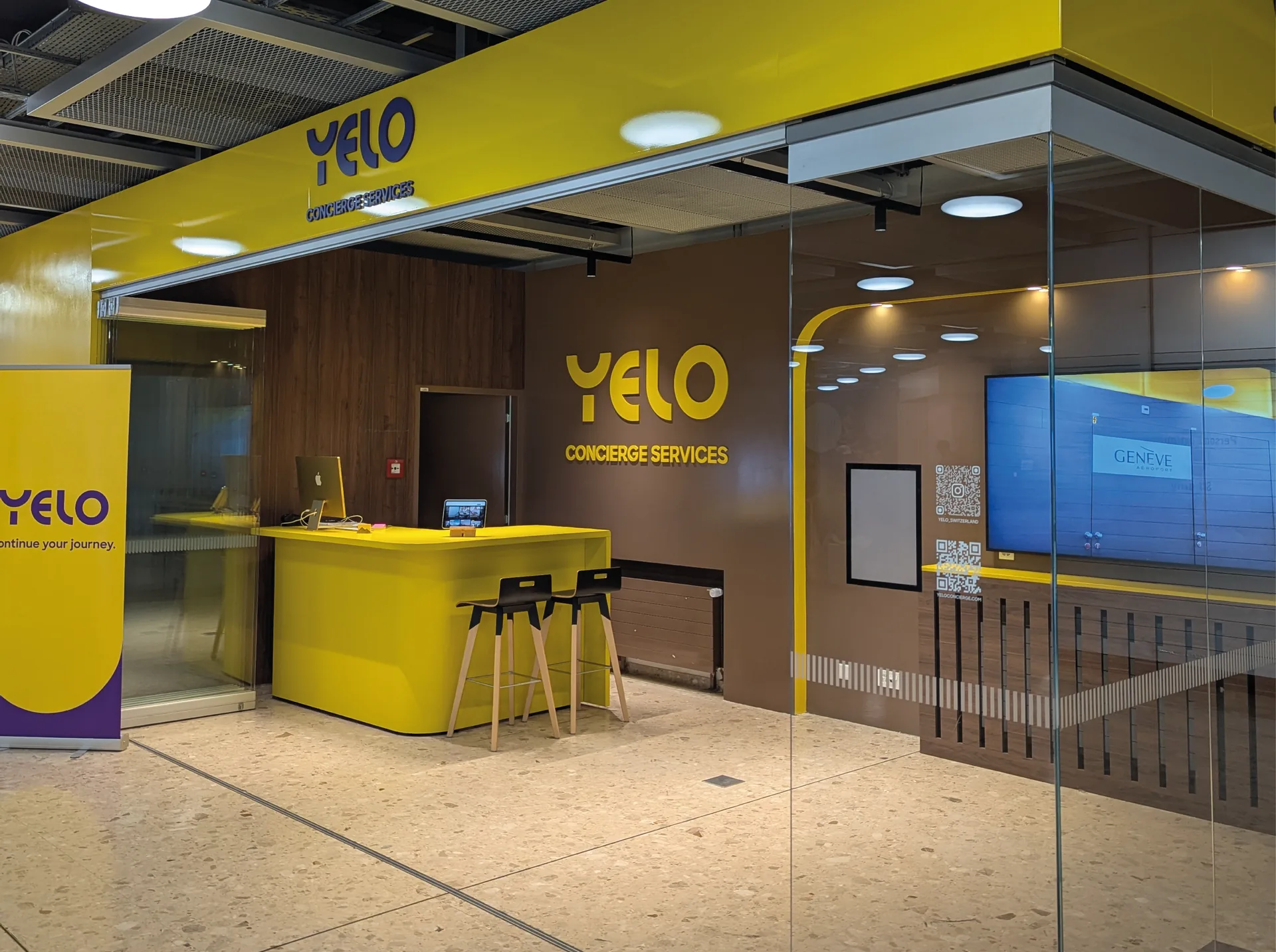 YELO Aéroport — Comptoir YELO Concierge Services habillé de son enseigne et de son lettrage mural, à l’aéroport